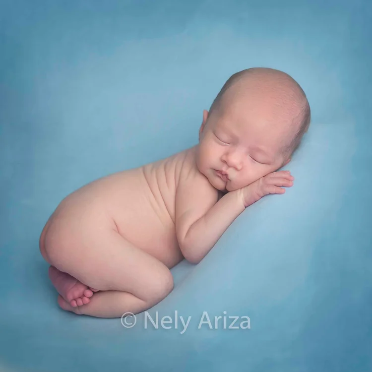 Foto de bebé recién nacido durmiendo desnudo.