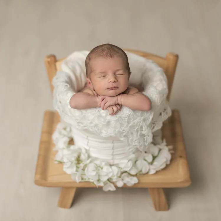 Fotografía de bebé recién nacido de Conil durmiendo en una cestita.