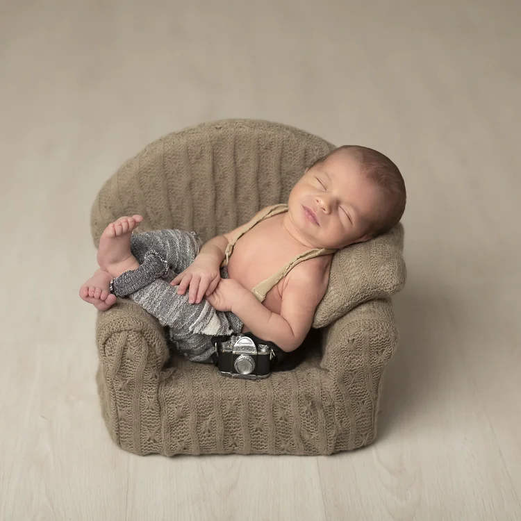 Fotografía de bebé recién nacido de Conil durmiendo en un sofá